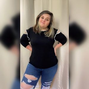 Adorable long sleeve black shirt with ruffle and arm slit detail and white trim